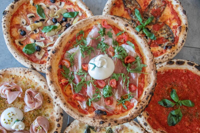 Frische Zutaten für Pizza auf einem rustikalen Tisch